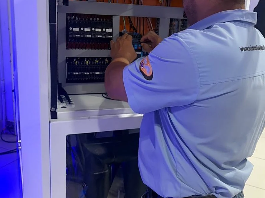 Eletricista da Automatiza trabalhando dentro do quadro elétrico em obra em Campinas.
