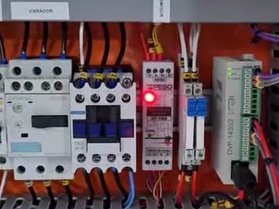 Quadro de comando industrial com contatores e bornes identificados.