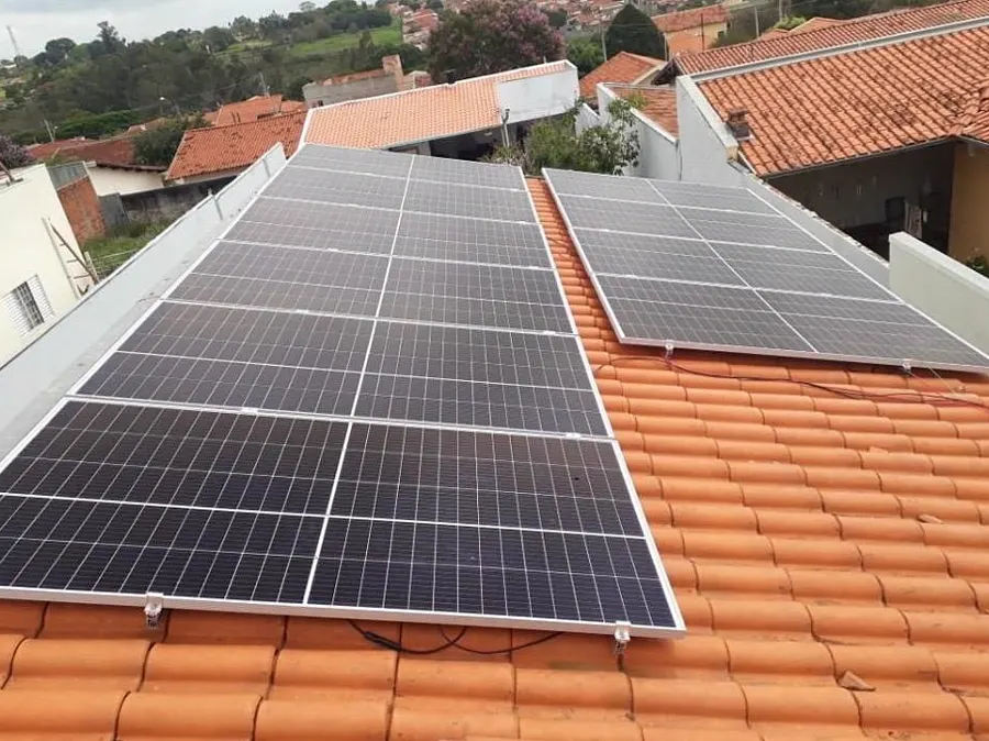 Painéis solares instalados em telhado cerâmico residencial.