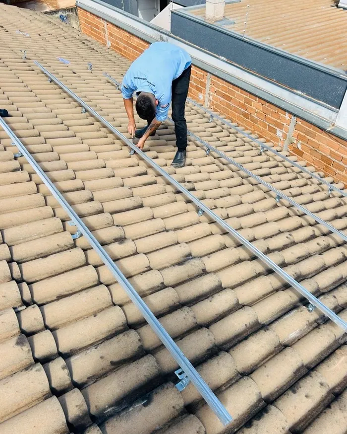 Técnico da Automatiza instalando a estrutura de fixação dos painéis no telhado.